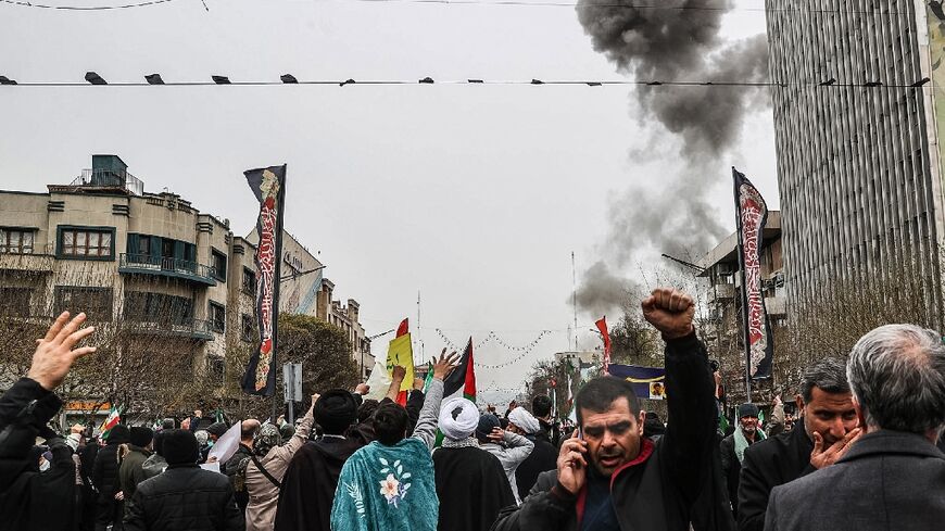 Black smoke rises after an airstrike in Tehran as Iranians take part in the Al-Quds (Jerusalem) Day rally on March 13, 2026