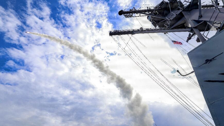 This US Navy handout photo shows the Arleigh Burke-class guided-missile destroyer USS Thomas Hudner (DDG 116) firing a Tomahawk land attack missile in support of Operation Epic Fury