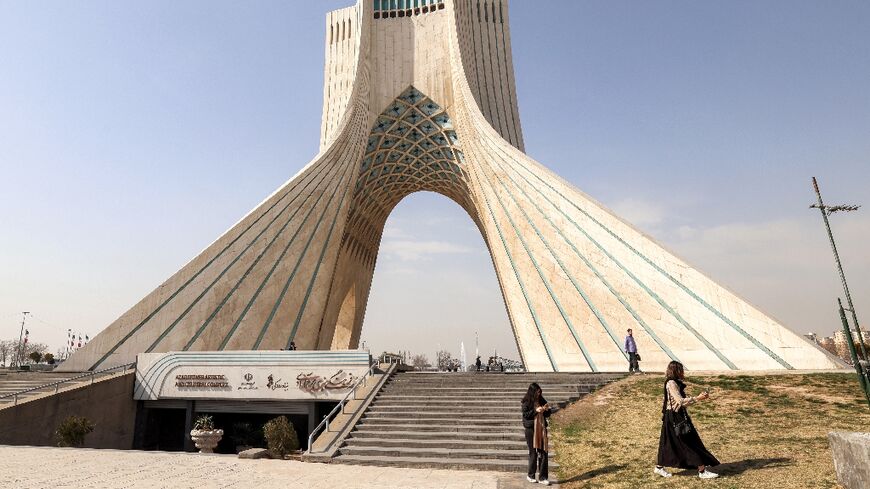 People walk near Tehran's landmark Azadi (Freedom) Tower in February before the United States and Israel launched a war a war against Iran