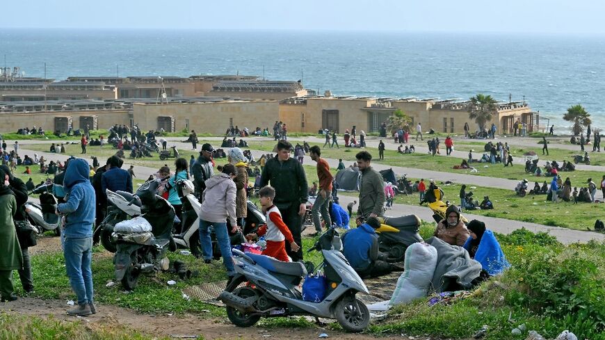 People who fled Beirut's southern suburbs after the latest Israeli bombing warning take refuge by a beach