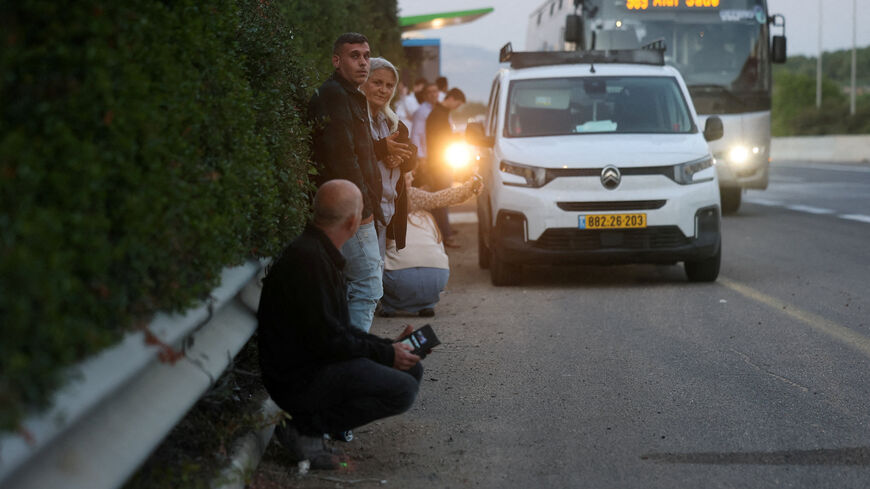 FILE PHOTO: People gather on the side of a road seeking protection as a rocket volley from Iran flies overhead, amid the U.S.-Israeli conflict with Iran, in northern Israel, March 17, 2026. REUTERS/Ammar Awad/File Photo
