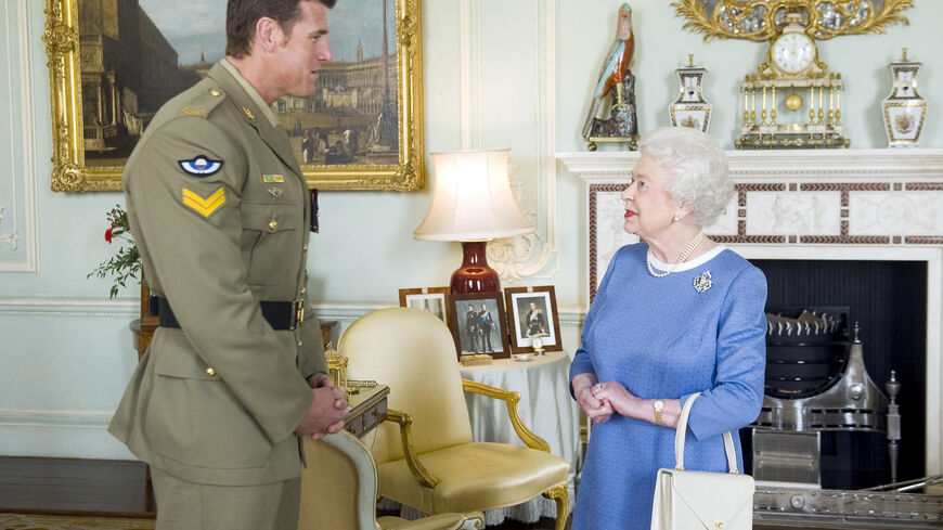 FILE PHOTO: Britain's Queen Elizabeth II greets Australian SAS Corporal Ben Roberts-Smith (L), who was recently awarded the Victoria Cross for Australia, during an audience at Buckingham Palace in London November 15, 2011.  REUTERS/Anthony Devlin/POOL/File Photo