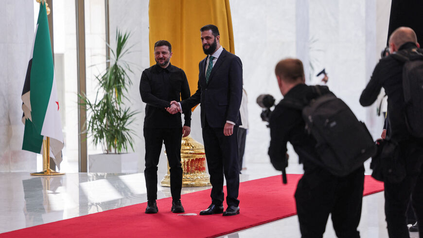 Ukraine's President Volodymyr Zelenskiy shakes hands with Syria's President Ahmed al-Sharaa as they meet in Damascus, Syria, April 5, 2026. REUTERS/Khalil Ashawi