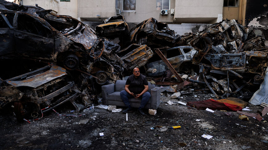 Mohamed El Junayd, 43, who said he survived the Israeli strike, sits beside piled damaged cars at the site of an Israeli strike carried out on April 8, at Corniche al-Mazraa in Beirut, Lebanon April 13, 2026. REUTERS/Zohra Bensemra