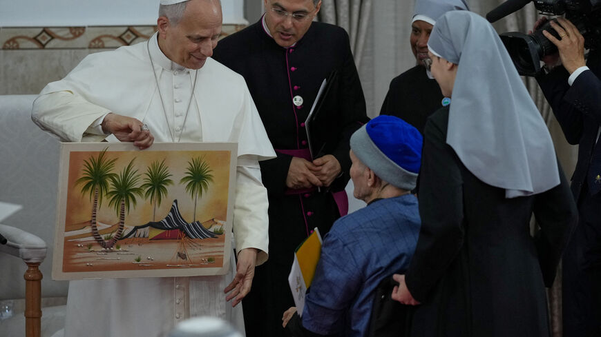 Pope Leo XIV is presented with a gift during his visit to the nursing home of the Little Sisters of the Poor in Annaba, Algeria, Tuesday, April 14, 2026. Andrew Medichini/Pool via REUTERS