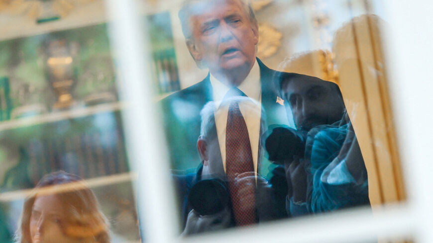 FILE PHOTO: News photographers wait for U.S. President Donald Trump to walk out of the Oval Office to speak with reporters at the White House in Washington, D.C., U.S., April 13, 2026. REUTERS/Jonathan Ernst/File Photo