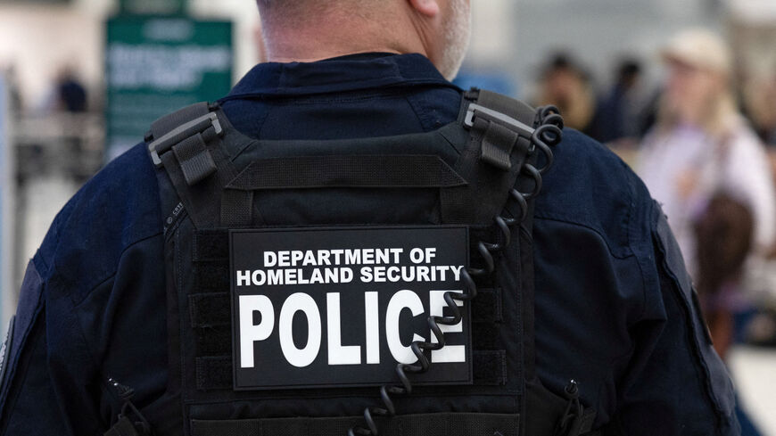 FILE PHOTO: A Department of Homeland Security officer directs passengers as they wait in long TSA lines at the George Bush Intercontinental Airport in Houston, Texas, U.S., March 25, 2026.    REUTERS/Antranik Tavitian/File Photo