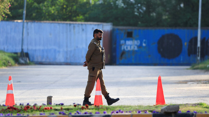 A police officer guards a road blocked with shipping containers, for security measures at D Chowk near the President's House as Pakistan prepares to host the United States and Iran for the second phase of peace talks in Islamabad, Pakistan, April 20, 2026. REUTERS/Akhtar Soomro