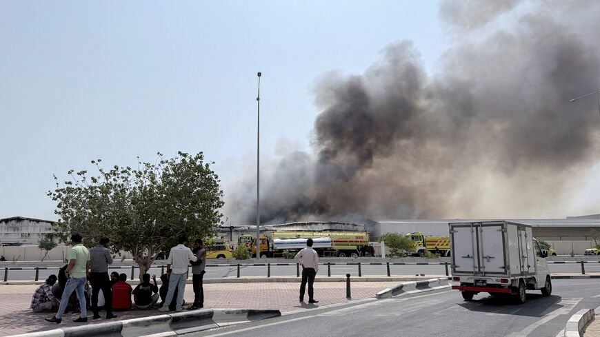 FILE PHOTO: People gather as smoke rises at the Industrial Area after reported Iranian missile attacks, following United States and Israel strikes on Iran, in Doha, Qatar, March 1, 2026. REUTERS/Mohammed Salem/File Photo