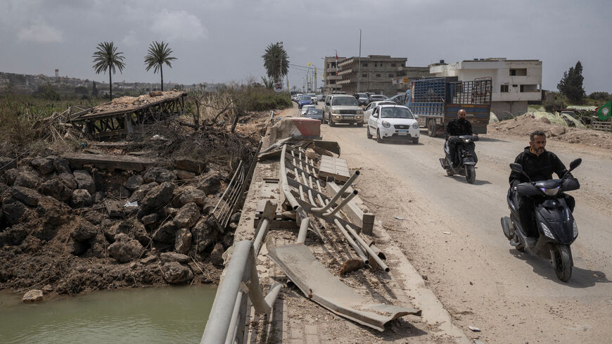 People travel in vehicles as displaced people make their way back to their homes, crossing the bridge linking southern Lebanon to the rest of the country, which was hit earlier in an Israeli strike, in Qasmiyeh, Lebanon, April 19.  REUTERS/Marko Djurica