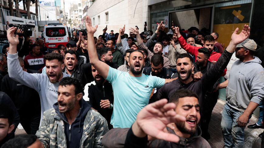 People react as the bodies of two Palestinians, who were killed during what the Palestinians said was an Israeli settler attack in Al-Mughayir village near Ramallah, are carried at a hospital in Ramallah, in the Israeli-occupied West Bank, April 21, 2026. REUTERS/Mohammed Torokman