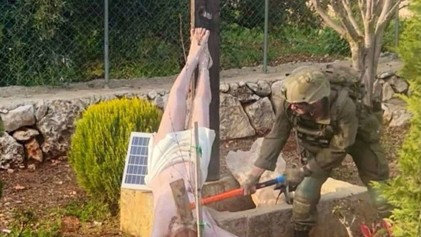 An Israeli soldier damages the head of a statue of Jesus, in Debel, Lebanon, in this still image obtained from social media released on April 19, 2026. Social Media/via REUTERS