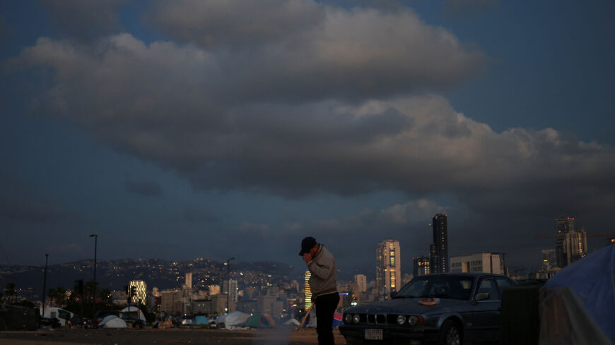 FILE PHOTO: A displaced man lights a fire outside his tent at a makeshift encampment, amid a 10-day ceasefire between Lebanon and Israel, in Beirut, Lebanon, April 21, 2026. REUTERS/Saleh Salem/File Photo