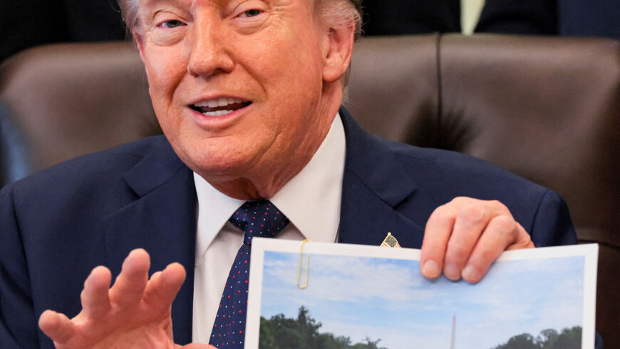 U.S. President Donald Trump shows an image as he speaks about renovations at the Lincoln Memorial Reflecting Pool during a healthcare affordability event in the Oval Office at the White House in Washington, D.C., U.S., April 23, 2026. REUTERS/Kylie Cooper