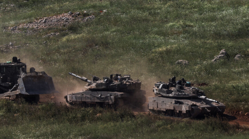 FILE PHOTO: Tanks and an armoured vehicle drive in Lebanon, as seen from the Israeli side of the Israel-Lebanon border, in northern Israel, April 25, 2026. REUTERS/Florion Goga/File Photo