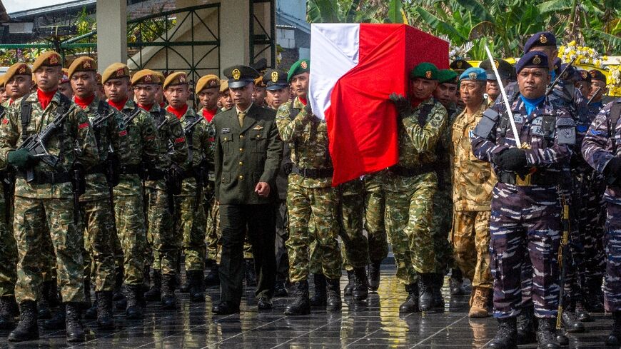 Military pallbearers carry the coffin of fallen compatriot and UN peacekeeper Farizal Rhomadhon during his funeral at the Giripeni Heroes' Cemetery in  Yogyakarta on April 5