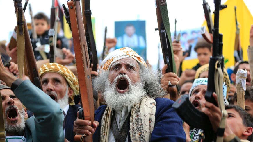 Supporters of the Iran-backed Houthi movement brandish their weapons as they rally in solidarity with Iran and Lebanon 
