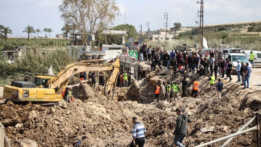 Lebanese civil defence personnel search for missing people next to the bomb-damaged Qasmiyeh bridge near the southern city of Tyre