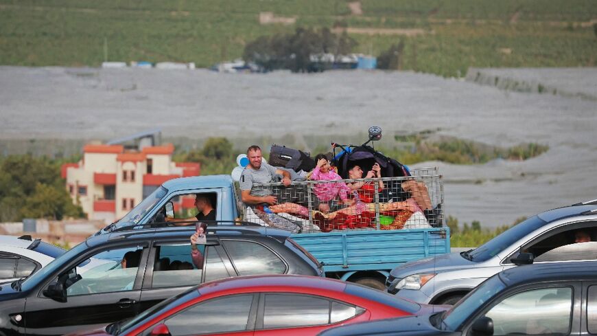 Displaced residents travel back to their homes via the bombed Qasmiyeh bridge over the Litani River 