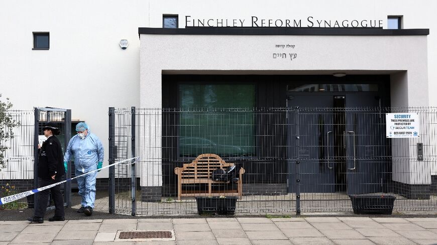 A police forensics officer investigates the scene of one of the attacks, on the Finchley Reform Synagogue
