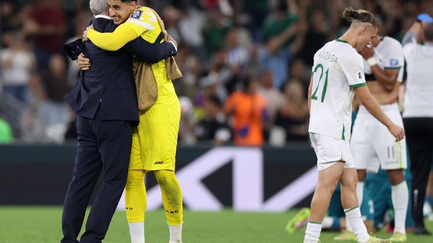 Iraq's Australian coach Graham Arnold celebrates with substitute goalkeeper Kumel Saadi after clinching World Cup qualification against Bolivia