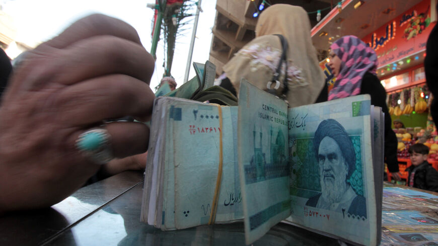 An Iraqi money dealer counts Iranian rial banknotes bearing a portrait of the late founder of the Islamic Republic of Iran, Ayatollah Ruhollah Khomeini, at an exchange office in Baghdad on Feb. 3, 2012. 