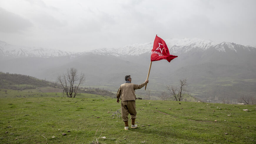 A armed Kurdish Peshmerga of the Komala party waves the Komala flag in a ceremony held in memory of Komala Martyrs' Day in Sidakan, Kurdistan Region of Iraq, on March 17, 2021.
