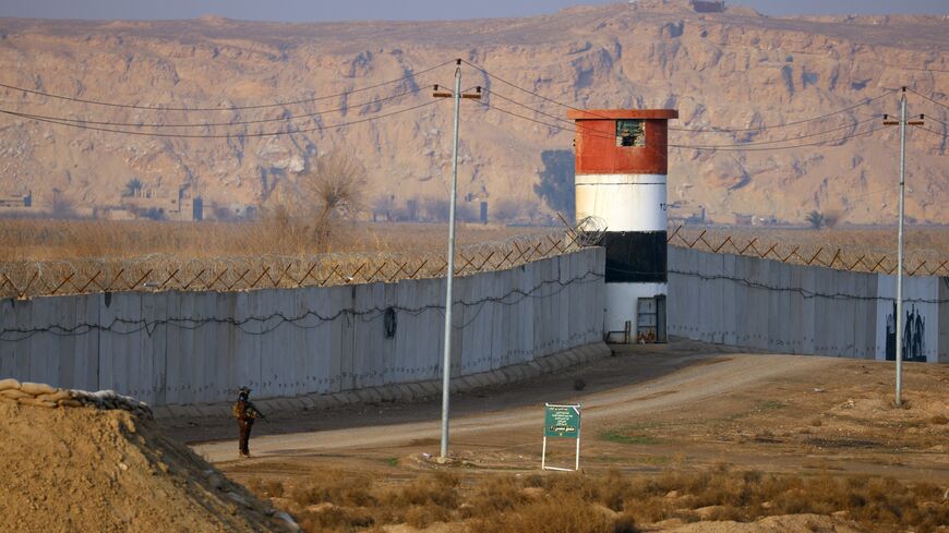 A member of the Popular Mobilization Forces patrols along a concrete wall at the Iraqi-Syrian border in Al-Qaim, west of Iraq, on Jan. 23, 2026. 