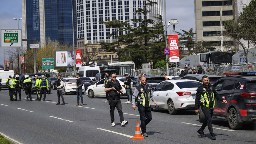 Police officials stand among traffic as they patrol near the Israeli Consulate following a shootout between gunmen and police, Istanbul, Turkey, April 7, 2026.