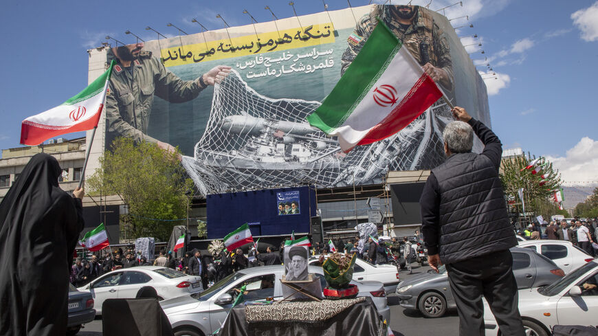 Iranians hold national flags as they gather in Tehran's Revolution Square after the United States and Iran agreed to a two-week ceasefire, on April 8, 2026 in Tehran, Iran. 