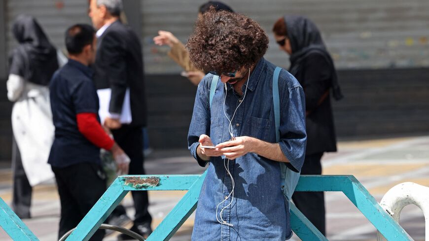 A man uses his mobile phone while standing at the Valiasr Square in Tehran on April 19, 2026. — ATTA KENARE / AFP via Getty Images