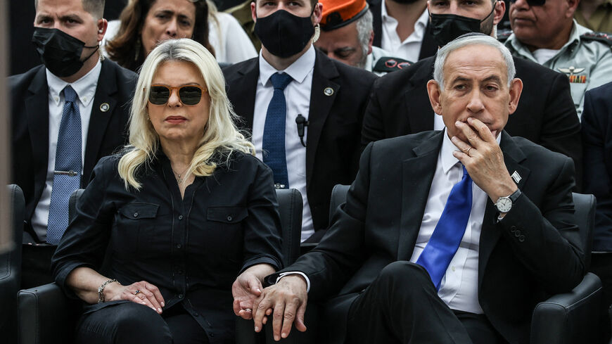 Israel's Prime Minister Benjamin Netanyahu holds the hand of his wife Sara as they attend a ceremony commemorating Israel's Remembrance Day for fallen soldiers, or Yom HaZikaron, at the Military Cemetery on Mount Herzl in Jerusalem on April 21, 2026. (Photo by Ilia YEFIMOVICH / POOL / AFP via Getty Images)