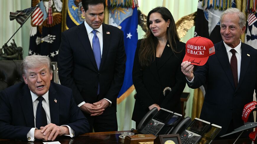 US Ambassador to Lebanon Michel Issa (R) holds a signed "Make America Great Again" hat while (L-R) US Secretary of State Marco Rubio and Lebanon Ambassador to the US Nada Hamadeh Moawad listen to US President Donald Trump speak during a meeting with Lebanon Ambassador to the US and Israel Ambassador to the US, at the White House in Washington, DC on April 23, 2026. US President Donald Trump met Lebanese and Israeli envoys at a new round of peace talks Thursday, with Beirut seeking a one-month extension of a