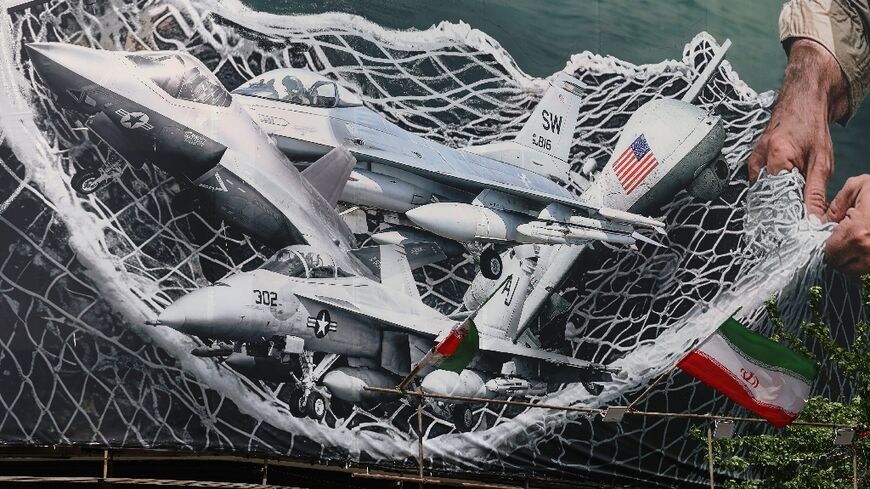 A giant billboard depicting Iranian troops using a net to catch US combat aircraft at Revolution Square in Tehran 