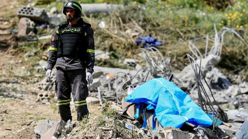 A first responder stands by a body bag as colleagues search for victims at the site of an Israeli airstrike in Lebanon's southern village of Saksakieh on May 9, 2026