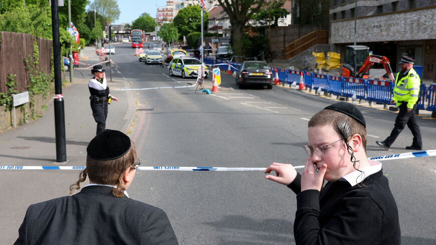 FILE PHOTO: Orthodox Jews stand by a police cordon, after a man was arrested following a stabbing incident in the Golders Green area, which is home to a large Jewish population, in London, Britain, April 29, 2026. REUTERS/Hannah McKay/File Photo