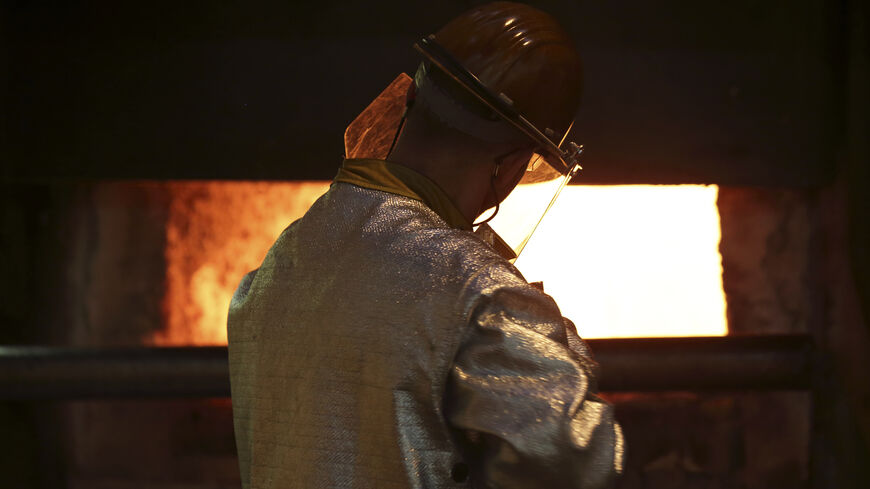 A worker cleans impurities from an aluminium furnace at the Renault factory in Cleon, Western France, July 20, 2015. The Renault plant constructs the R240 electrical car engine, with an autonomy of 240 kilometres, for its Zoe line of automobiles. The plant has a current production capacity of 50,000 engines that can be increased to 100,000 units. Picture taken July 20, 2015.   REUTERS/Philippe Wojazer