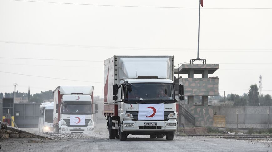 Turkish Red Crescent's cars and trucks cross the Turkish border as they leave the Syrian city of Tel Abyad on Oct. 19, 2019, in Akcakale, Turkey. 