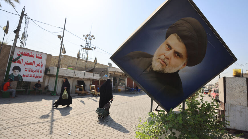 Iraqis walk past portraits of Iraqi Shiite cleric Muqtada al-Sadr, including one on a banner calling for a boycott of the upcoming parliamentary elections in Sadr City, east of Baghdad on October 29, 2025. Parliamentary elections are scheduled to be held in Iraq on 11 November 2025, which will determine the 329 members of Iraq's Council of Representatives, who are responsible for electing the country's president and approving the appointment of the prime minister. (Photo by AHMAD AL-RUBAYE / AFP) (Photo by 