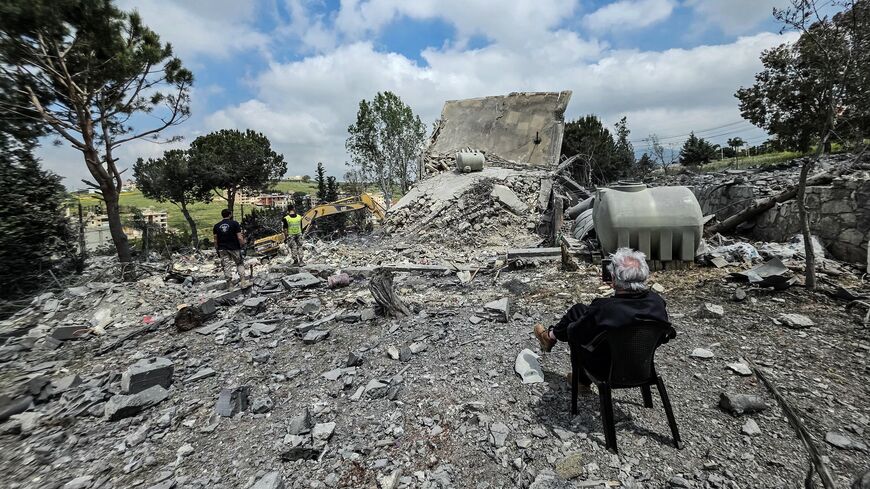 A man sits watching as Lebanese first responders search for human remains among the rubble the day after a house was targeted in an Israeli airstrike in the southern Lebanese city of Nabatieh, on May 1, 2026. 