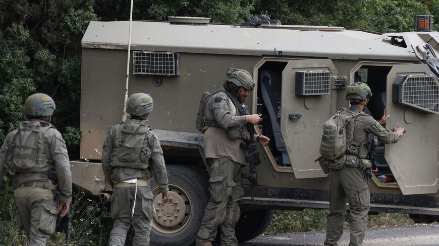 Israeli soldiers react after taking cover near the Israel-Lebanon border following a Hezbollah drone attack that hit the northern border on May 19, 2026. The Israeli military on May 19 warned residents of 12 towns and villages in southern Lebanon to immediately evacuate ahead of expected attacks against Hezbollah, the latest despite a ceasefire. (Photo by Jalaa MAREY / AFP via Getty Images)
