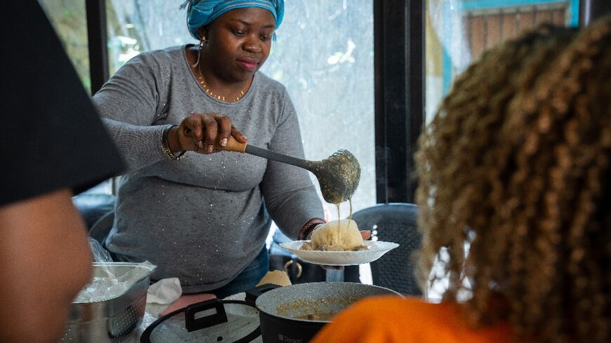 A volunteer serves food at REMAN, an organisation supporting migrant workers