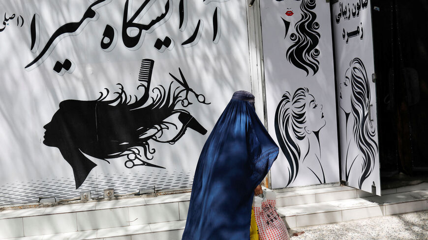 An Afghan woman walks past a beauty salon in Kabul, Afghanistan, July 6, 2023. REUTERS/Ali Khara/File Photo