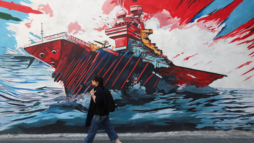 An Iranian woman walks next to an anti-U.S. mural on a street in Tehran, Iran, June 10, 2026. Majid Asgaripour/WANA (West Asia News Agency) via REUTERS