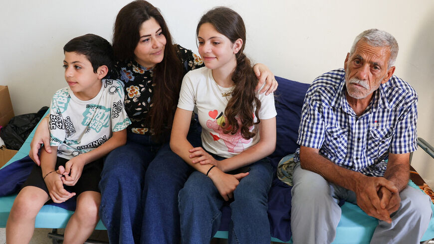 FILE PHOTO: Darine Al Jouny Safadi, 38, her children Salma and Eliya, and her father Youssef Al Jouny, a Christian family displaced from Tyre, southern Lebanon, sit in a room where they take refuge at the House of Saint Anne for Youth, overseen by the Greek Melkite Catholic Patriarchate, in Rabweh, Lebanon, June 10, 2026. REUTERS/Mohamed Azakir/File Photo