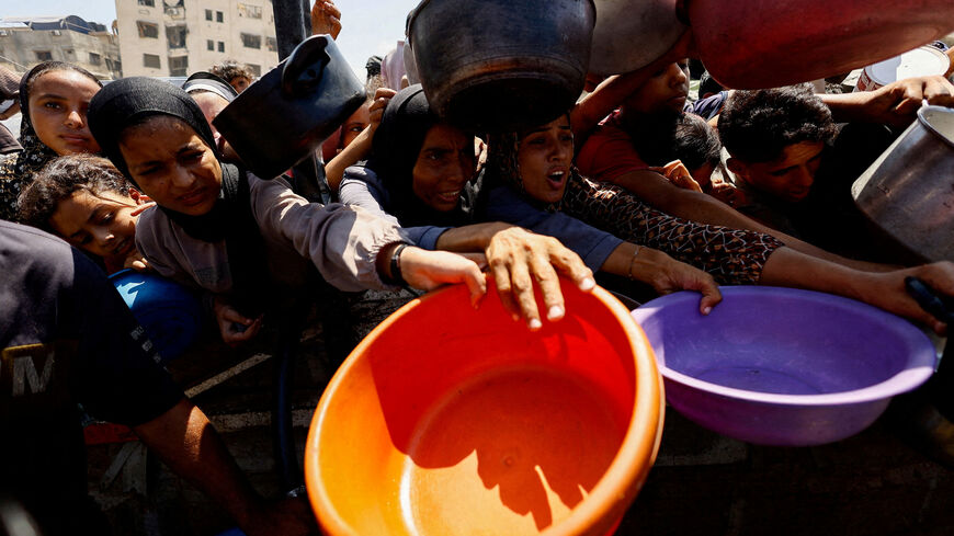FILE PHOTO: Palestinians wait to receive food from a charity kitchen in Gaza City, August 28, 2025. REUTERS/Mahmoud Issa/File Photo