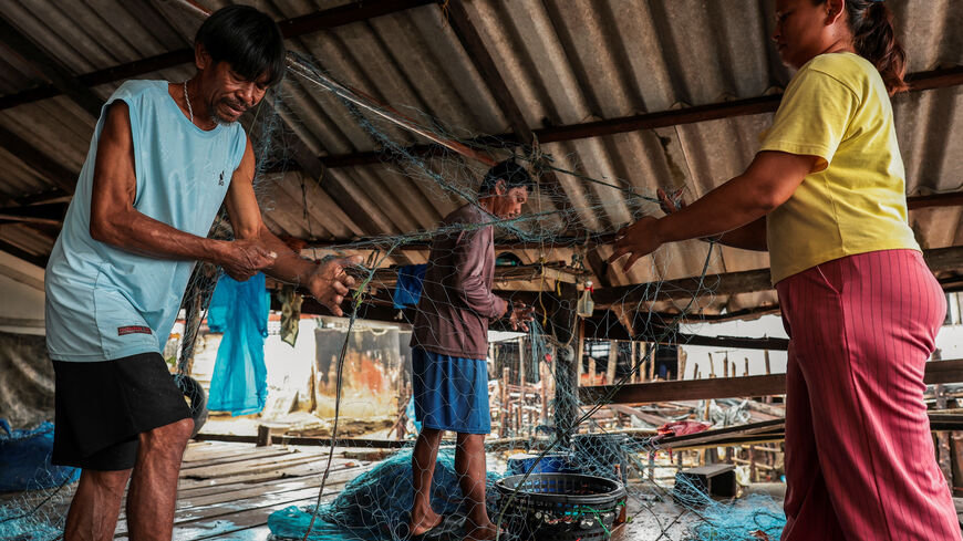 Chaiyaporn Arunrasamee, 50, a local fisherman, works on a fishing net with his relatives on Koh Haad Sai Dam Island, in Ranong province, Thailand, May 20, 2026. REUTERS/Chalinee Thirasupa