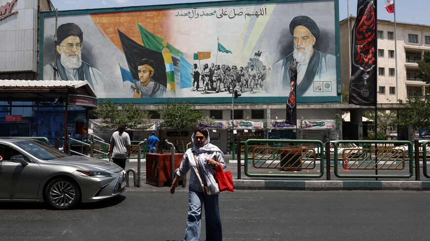 A woman walks near a mural depicting the late leader of the Islamic Revolution, Ayatollah Ruhollah Khomeini, and Iran's late Supreme Leader Ayatollah Ali Khamenei, on a street in Tehran, Iran, June 18, 2026. Majid Asgaripour/WANA (West Asia News Agency) via REUTERS