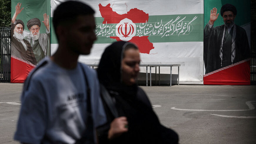FILE PHOTO: People walk past a banner with pictures of the late leader of the Islamic Revolution, Ayatollah Ruhollah Khomeini, the late Iran's Supreme Leader Ayatollah Ali Khamenei, and Iran's Supreme Leader Mojtaba Khamenei, on a street in Tehran, Iran, June 9, 2026. Majid Asgaripour/WANA (West Asia News Agency) via REUTERS