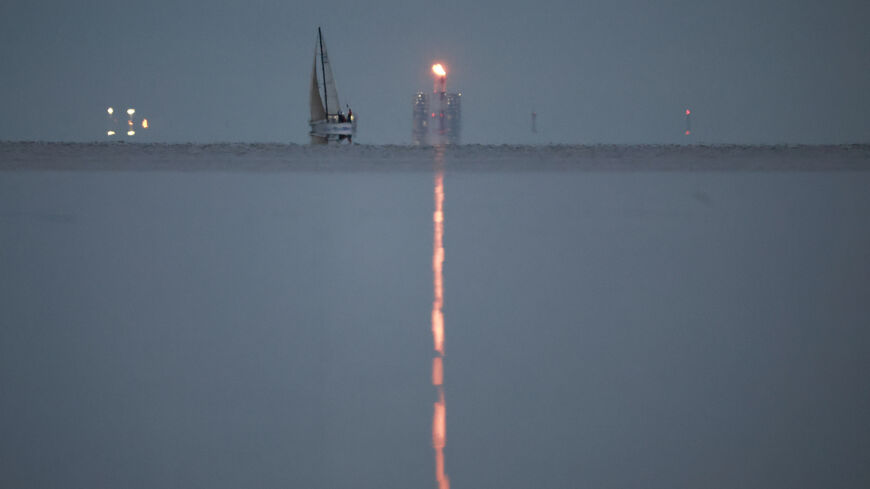 A yacht sails past a gas flare at Portovaya Bay on the coast of the Gulf of Finland in the Leningrad Region, Russia August 26, 2022. REUTERS/Stringer